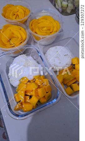 Mango sticky rice, a traditional Thai dessert featuring sweet glutinous rice paired with ripe mango slices and rich coconut cream. A delightful blend of tropical flavors and textures. 129307272