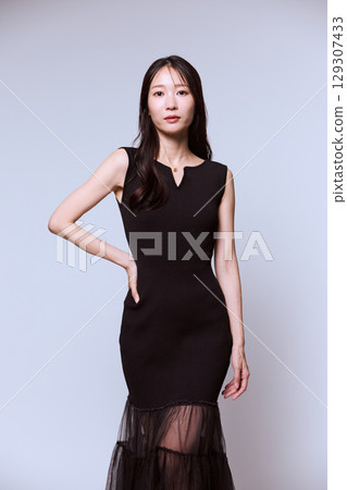 一位身穿黑色連身裙的女模特兒的工作室肖像 一位身穿黑色連身裙的女模特兒的工作室肖像 129307433