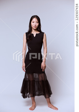 一位身穿黑色連身裙的女模特兒的工作室肖像 一位身穿黑色連身裙的女模特兒的工作室肖像 129307434