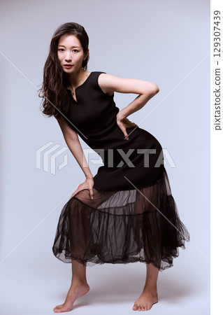 一位身穿黑色連身裙的女模特兒的工作室肖像 129307439