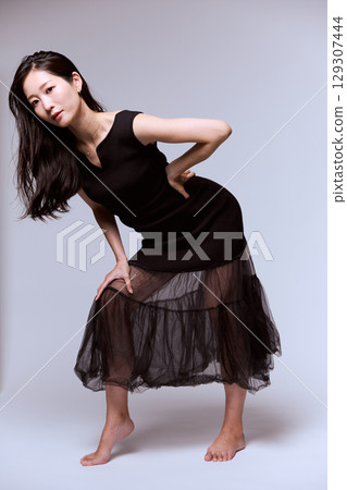 一位身穿黑色連身裙的女模特兒的工作室肖像 129307444