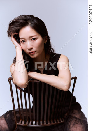 一位身穿黑色連身裙的女模特兒的工作室肖像 一位身穿黑色連身裙的女模特兒的工作室肖像 129307461