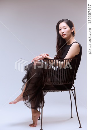 Studio portrait of a female model posing in a black dress Studio portrait of a female model posing in a black dress 129307467