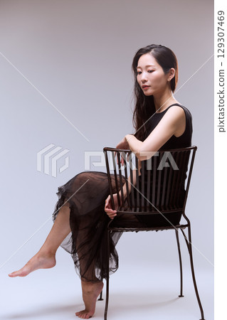 一位身穿黑色連身裙的女模特兒的工作室肖像 一位身穿黑色連身裙的女模特兒的工作室肖像 129307469