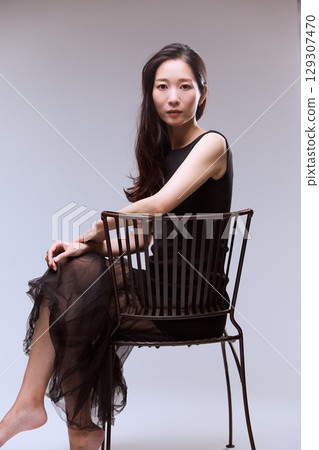 一位身穿黑色連身裙的女模特兒的工作室肖像 129307470