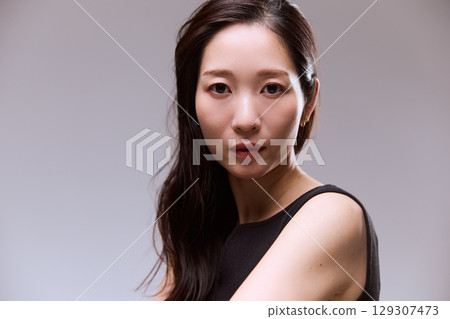 Studio portrait of a female model posing in a black dress Studio portrait of a female model posing in a black dress 129307473