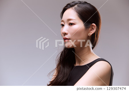 一位身穿黑色連身裙的女模特兒的工作室肖像 一位身穿黑色連身裙的女模特兒的工作室肖像 129307474