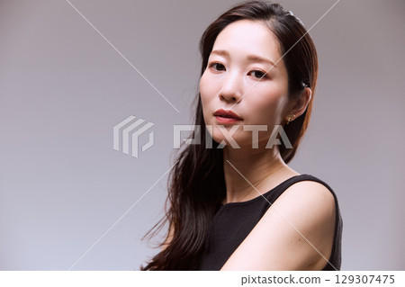 一位身穿黑色連身裙的女模特兒的工作室肖像 129307475