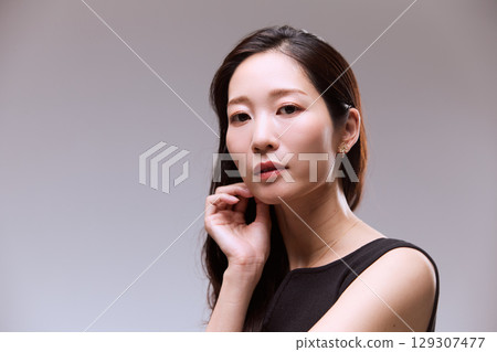一位身穿黑色連身裙的女模特兒的工作室肖像 129307477