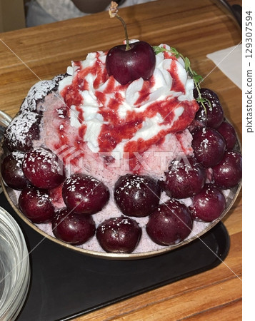 Refreshing cherry bingsu topped with juicy cherries, fluffy shaved ice, sweet syrup, and creamy condensed milk perfect for a fruity and cooling summer dessert. Refreshing cherry bingsu topped with juicy cherries, fluffy shaved ice, sweet syrup, and creamy condensed milk perfect for a fruity and cooling summer dessert. 129307594