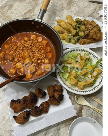 Korean meal set with spicy rabokki, fresh salad, crispy nuggets, and assorted twigim perfect harmony of spicy, crunchy, and refreshing flavors in one delicious platter. 129307599