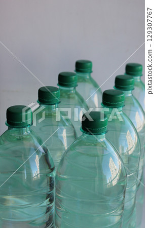 Rows of plastic bottles with clean water angled view studio isolated Rows of plastic bottles with clean water angled view studio isolated 129307767