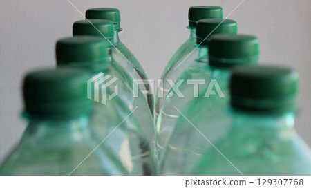 Two rows of plastic water bottles with focus on the last bottles isolated on white Two rows of plastic water bottles with focus on the last bottles isolated on white 129307768