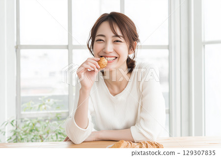 A woman eating breakfast  A woman eating breakfast  129307835