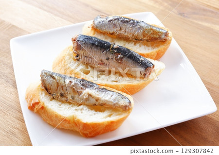 Sardines in Oil and Baguette - Sardines marinated in olive oil and freshly baked baguette 129307842