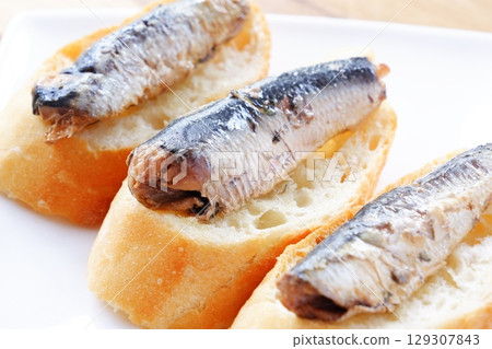 Sardines in Oil and Baguette - Sardines marinated in olive oil and freshly baked baguette 129307843
