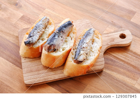 Sardines in Oil and Baguette - Sardines marinated in olive oil and freshly baked baguette 129307845