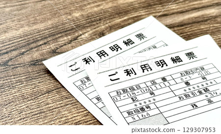 棕色板背景上的兩張銀行 ATM 收據 棕色板背景上的兩張銀行 ATM 收據 129307953