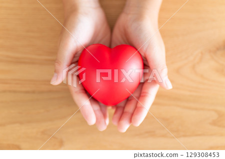 Elementary school boy's hand holding a heart Elementary school boy's hand holding a heart 129308453
