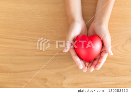 Elementary school boy's hand holding a heart Elementary school boy's hand holding a heart 129308513