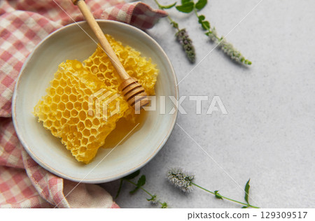 Honeycomb in bowl with honey dipper and fresh mint Honeycomb in bowl with honey dipper and fresh mint 129309517