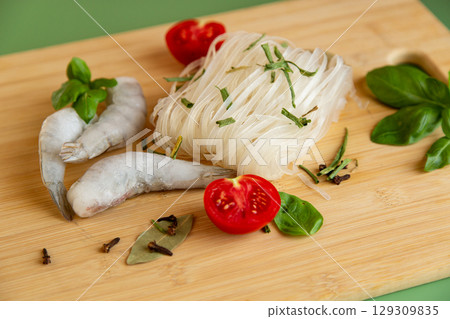 Preparing dinner rice noodles raw shrimp protein and green spices Preparing dinner rice noodles raw shrimp protein and green spices 129309835