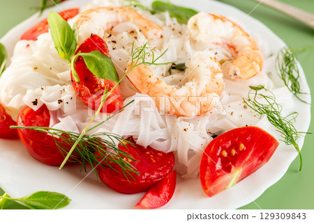 Gourmet still life of white rice pasta shrimp tomatoes and greens Gourmet still life of white rice pasta shrimp tomatoes and greens 129309843