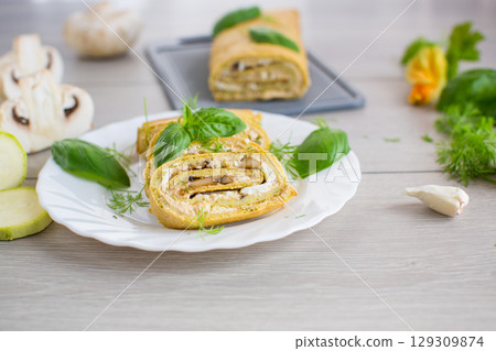zucchini roll cooked with cheese filling and mushrooms, on light wooden table 129309874