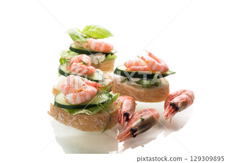 Isolated mini canapes with shrimps, salad leaves and cucumber 129309895