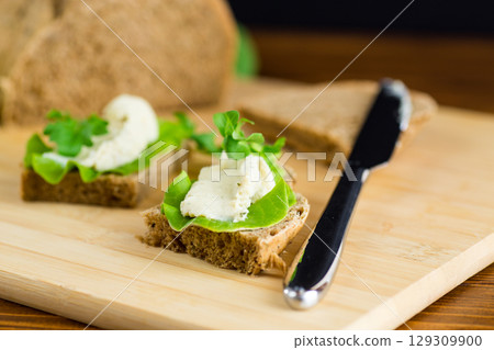 Healthy sandwich with arugula, salad and soft cheese 129309900