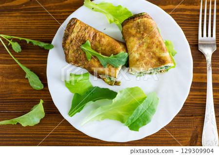 Breakfast with omelette, salad and fresh green herbs 129309904