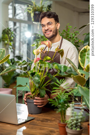 Young man at the laptop in the flower shop 129310399
