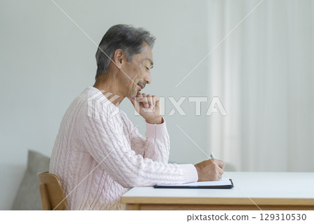 一位老人用筆寫字的側面像 一位老人用筆寫字的側面像 129310530