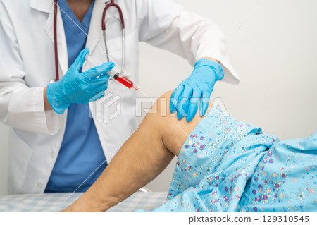 Asian doctor inject Hyaluronic acid platelet rich plasma into knee of senior woman. 129310545