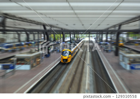 ROTTERDAM, NETHERLANDS, August 1, 2025. Yellow and blue NS train on the platform of Rotterdam Central Station with passengers 129310558