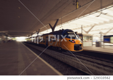 ROTTERDAM, NETHERLANDS, August 1, 2025. Yellow and blue NS train on the platform of Rotterdam Central Station with passengers 129310562