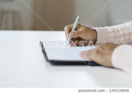 Senior man's hand holding a pen 129310649