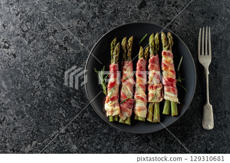 Grilled green asparagus wrapped in bacon. Grilled green asparagus wrapped in bacon. 129310681