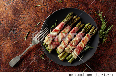 Grilled green asparagus wrapped in bacon. 129310683