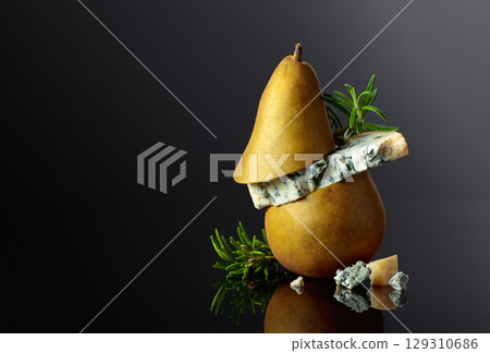 Blue cheese with pear and rosemary on a black background. Blue cheese with pear and rosemary on a black background. 129310686