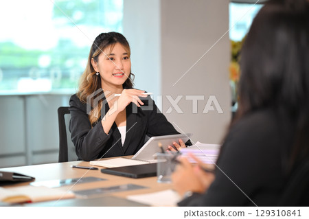 Confident businesswoman sharing strategic insights during meeting in a bright modern office Confident businesswoman sharing strategic insights during meeting in a bright modern office 129310841