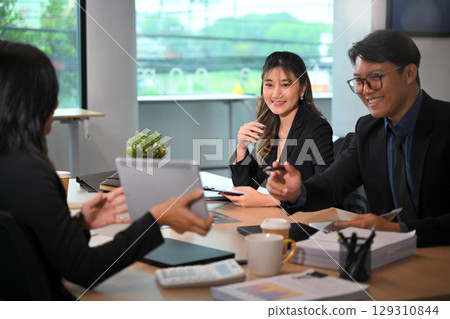 Corporate team sharing strategies and reviewing reports in a bright modern office 129310844