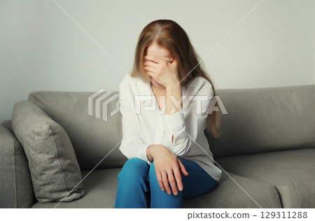 Exhausted tired woman suffering from headache, stress, fatigue, temples pain, migraine, loud noise 129311288