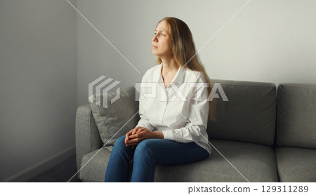 Pensive woman thinks looks out the window, thoughtful girl suffering from depression at home Pensive woman thinks looks out the window, thoughtful girl suffering from depression at home 129311289