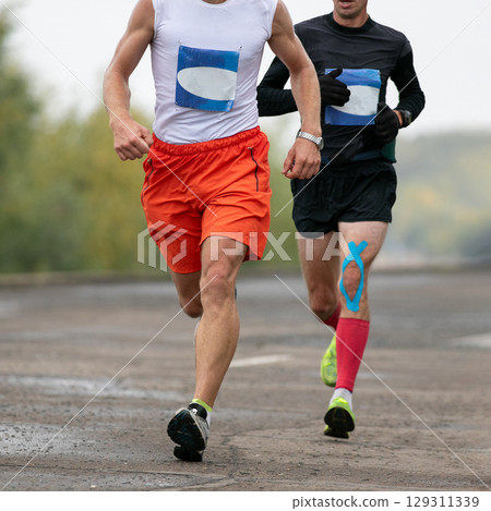 two man runners running in river embankment marathon race two man runners running in river embankment marathon race 129311339