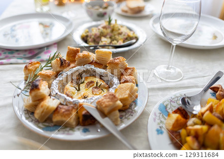 Delicious homemade meals served on elegant white tablecloth for holiday event, cozy festive atmosphere with traditional home cooking. Close up 129311684