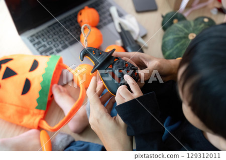Halloween Crafts. Child and adult creating spooky decorations with pumpkins and crafts. 129312011