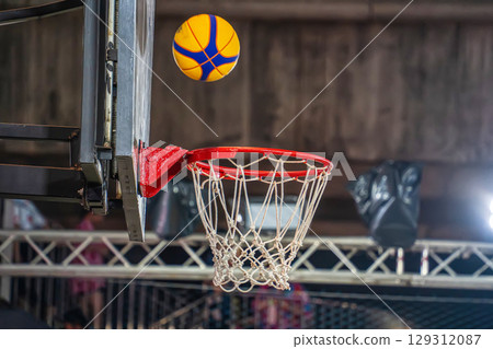 Basketball Mid-Air Above Hoop 129312087