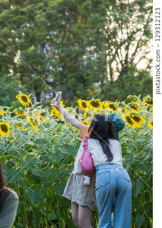 Girls Taking Selfie with Sunflowers Girls Taking Selfie with Sunflowers 129312123