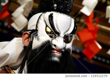 Iwami Kagura (Night Kagura) Performers dancing on the shrine's worship hall stage 129312270